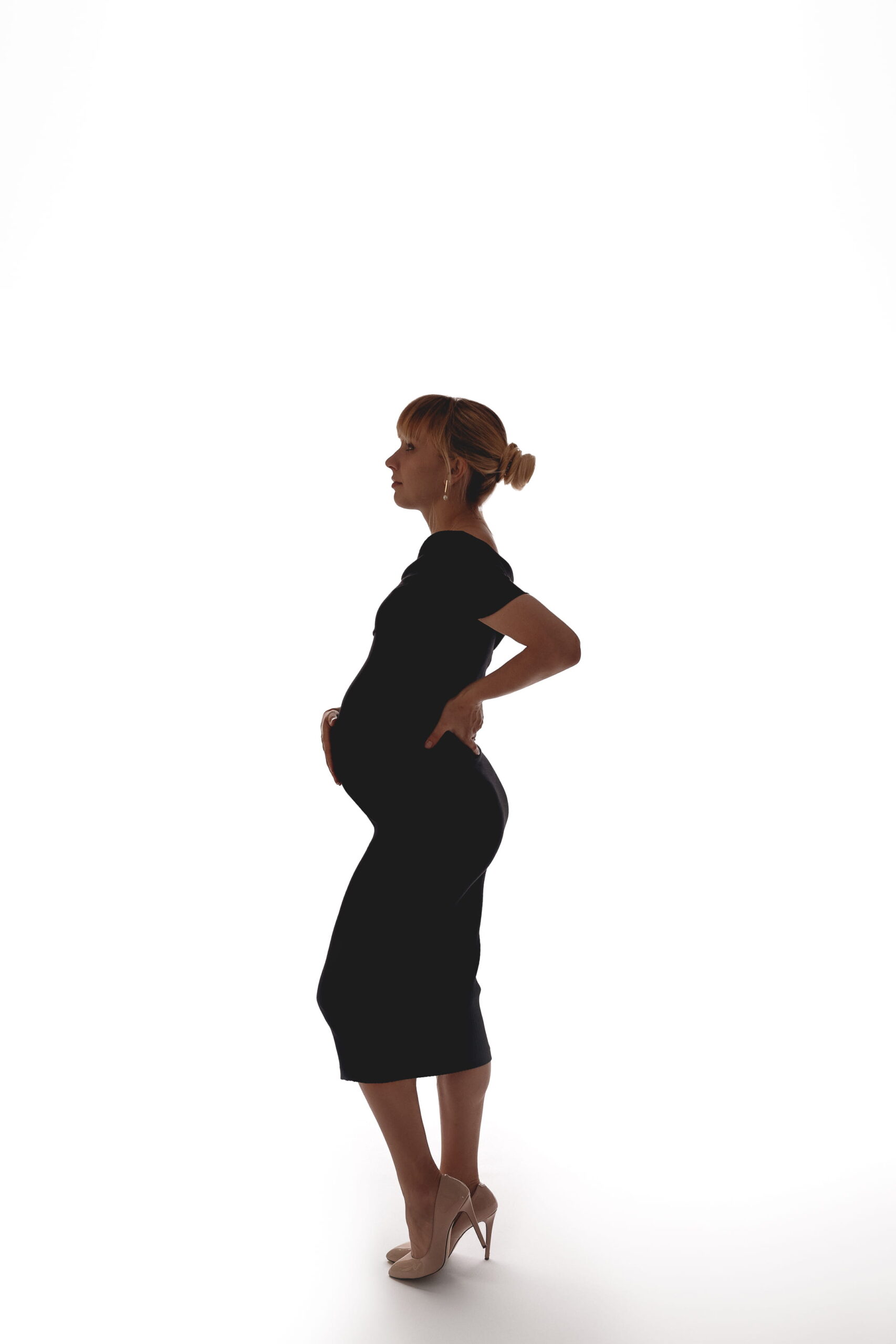 sessão de gravida no porto. fotografia a cores, gravida vestida com vestido preto elegante e de salto alto com cabelo apanhado